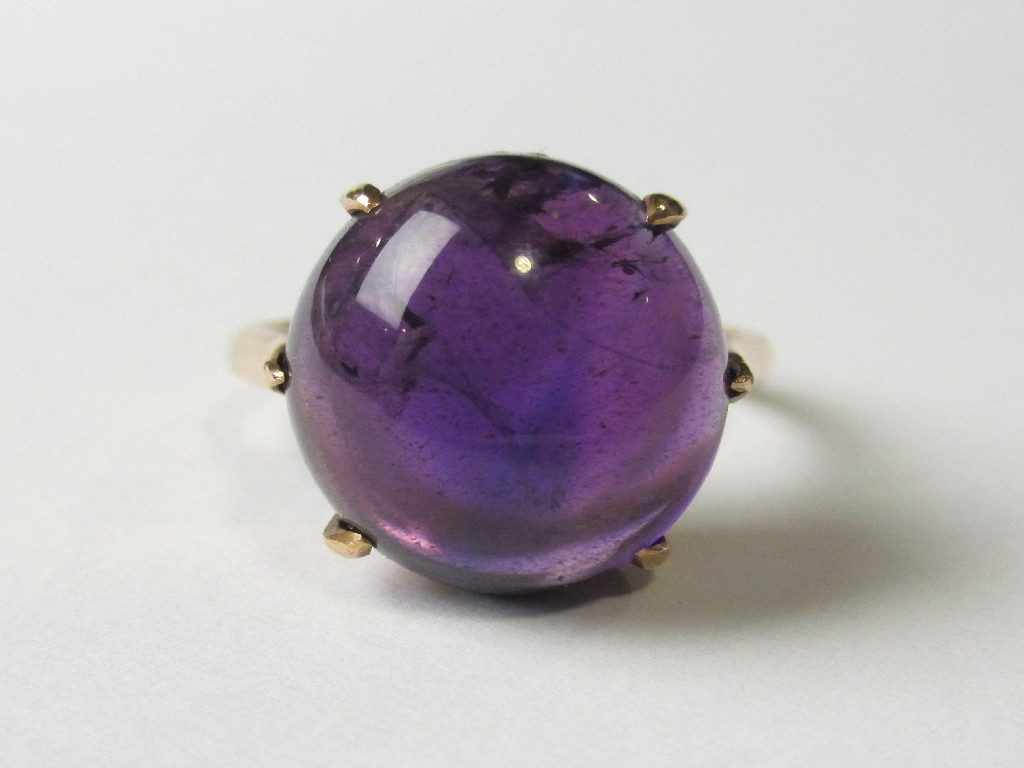 Appraisal: A fourteen carat rose gold cabochon amethyst set dress ring