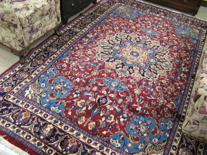 Appraisal: PERSIAN MASHAD CARPET floral and central floral medallion design on