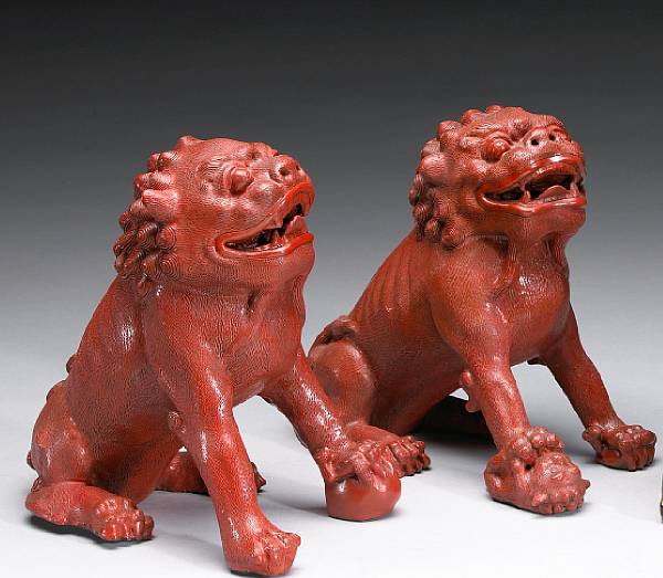 Appraisal: A pair of red lacquered lions Each modeled in a