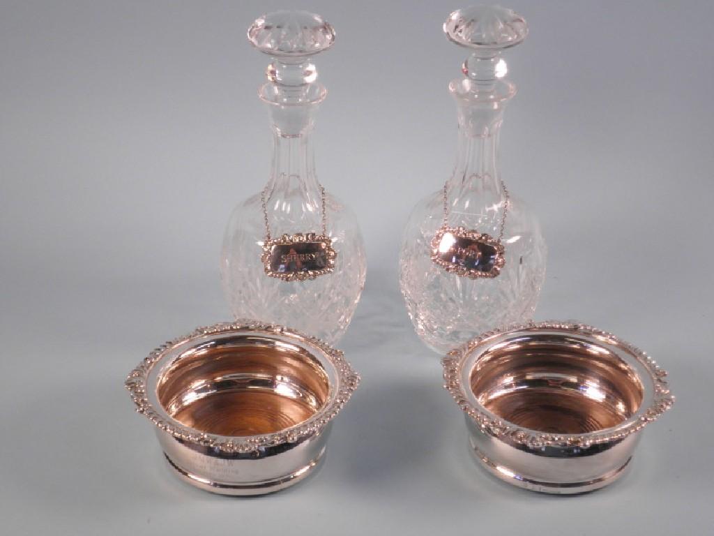 Appraisal: A pair of silver plated coasters cut glass decanters and