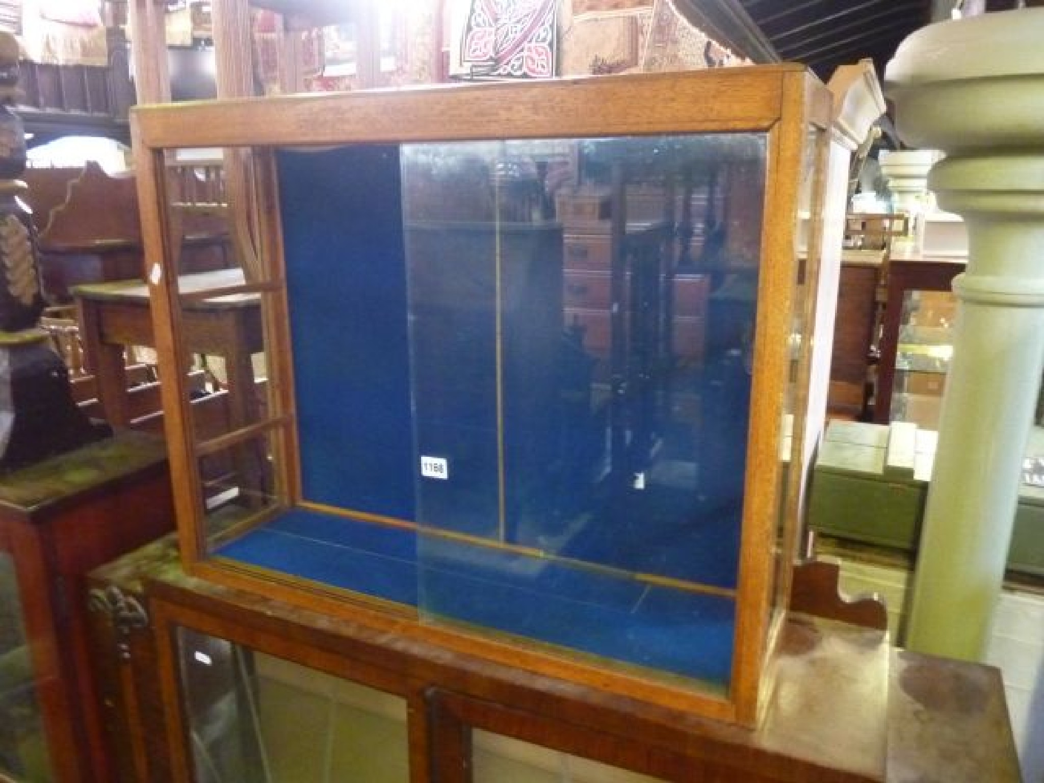 Appraisal: An oak framed display cabinet fitted with two sliding glass