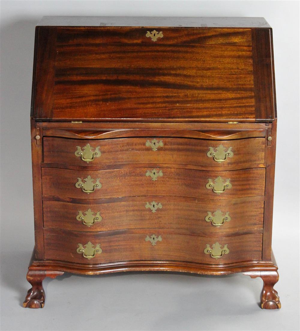 Appraisal: CHIPPENDALE STYLE MAHOGANY REVERSE SERPENTINE SLANT TOP DESK having a