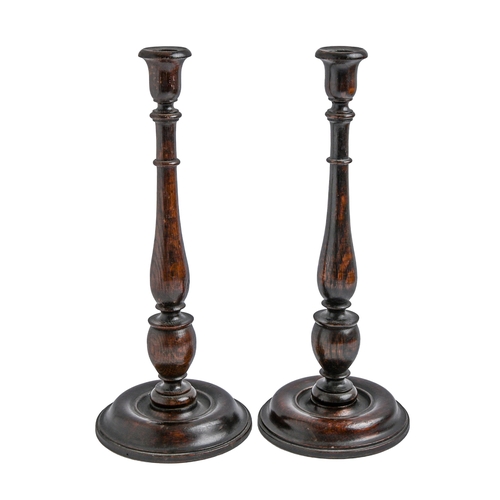 Appraisal: A pair of turned and stained oak baluster candlesticks early