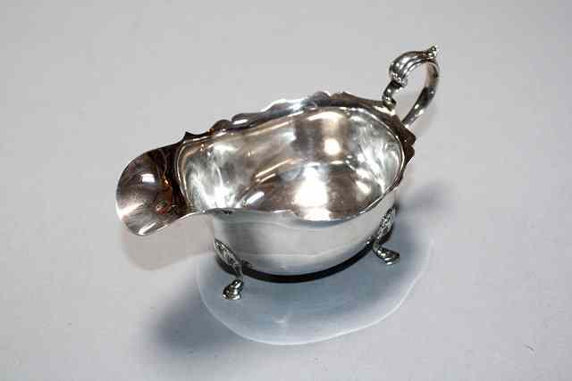 Appraisal: A SILVER SAUCE BOAT with a wavy edge hoof feet