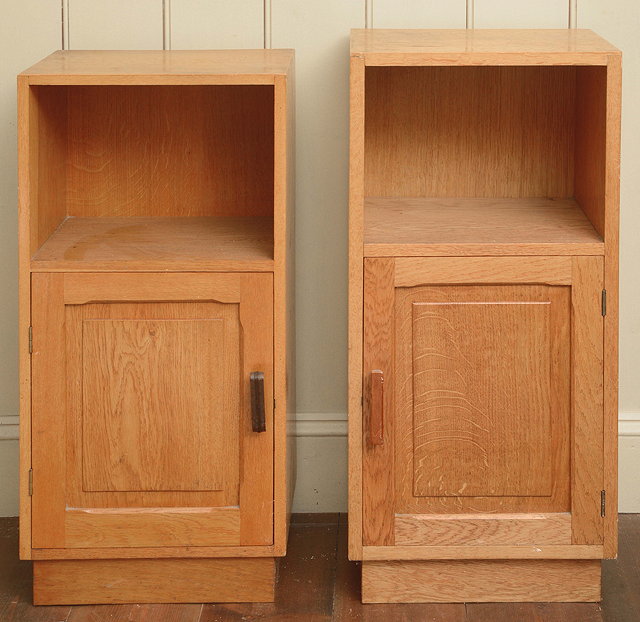 Appraisal: A MATCHED PAIR OF OAK BEDSIDE CUPBOARDS in the manner