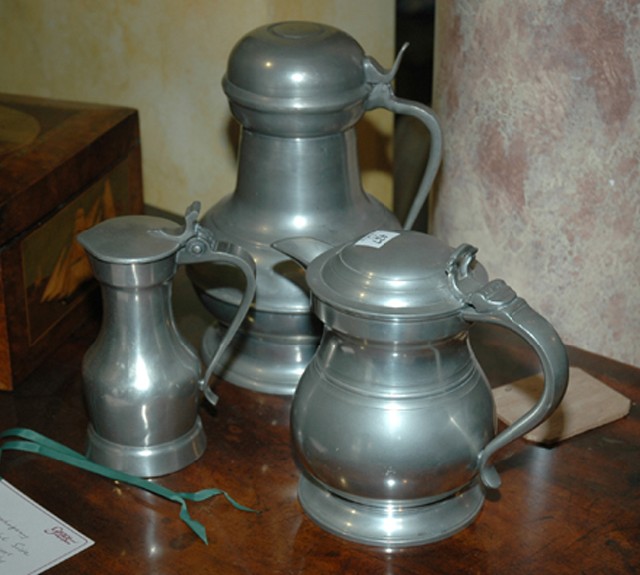 Appraisal: THREE PEWTER FLAGONS Early th century The largest cm high