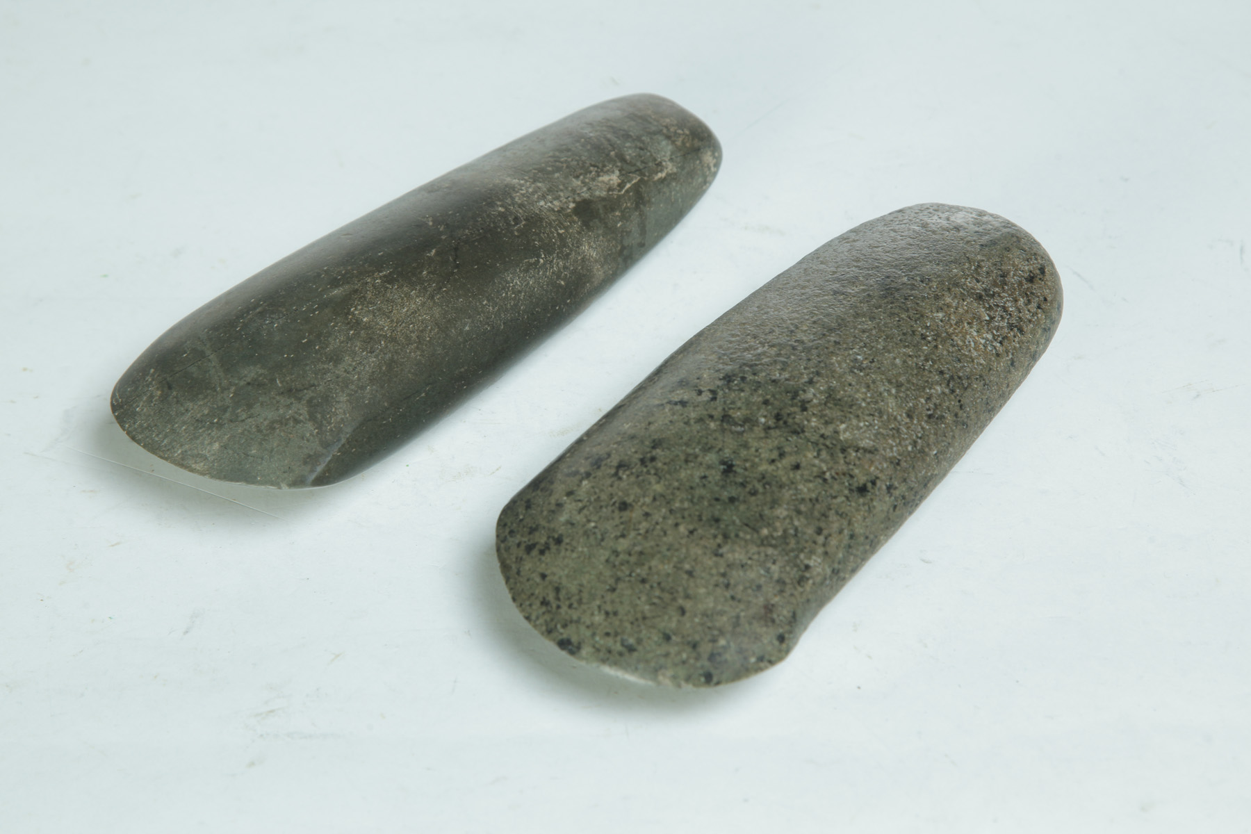 Appraisal: TWO STONE CELTS Flare bit and polished diorite axe heads