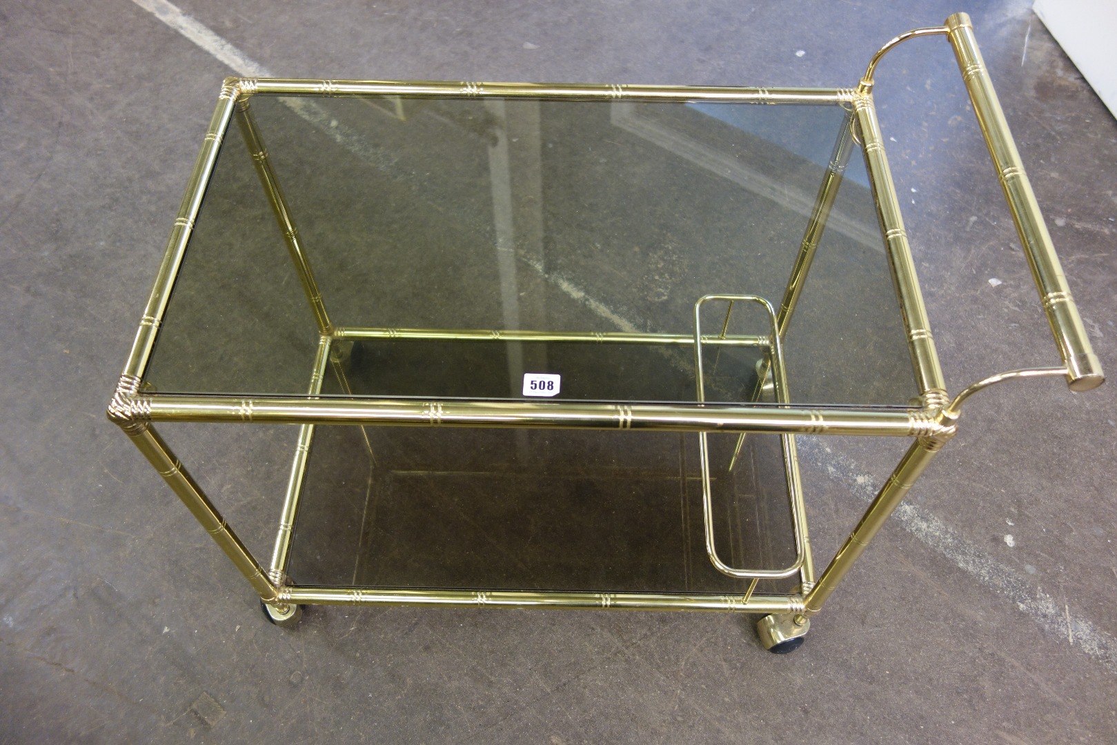 Appraisal: A modern gilt metal two tier drinks trolley the faux