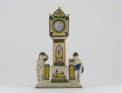 Appraisal: A Prattware watch-stand modelled as a longcase clock between two