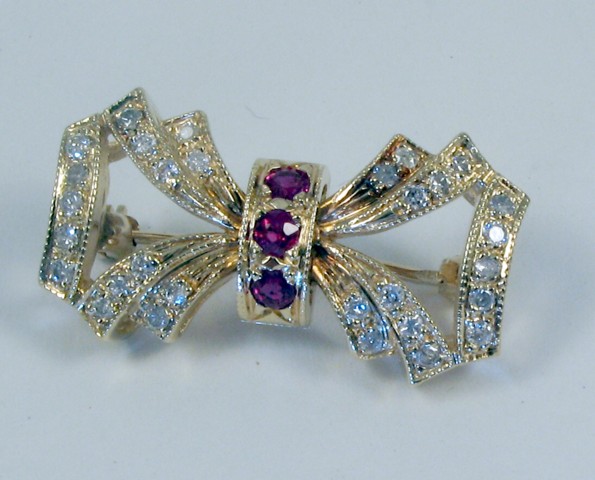 Appraisal: RUBY AND DIAMOND BROOCH k yellow gold and set with