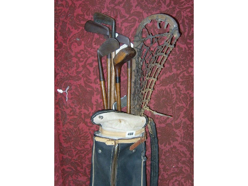 Appraisal: A golf bag containing a collection of golf clubs and