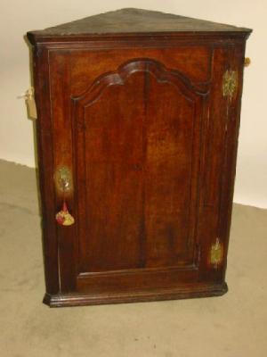 Appraisal: A GEORGE III OAK CORNER CUPBOARD the moulded cornice over