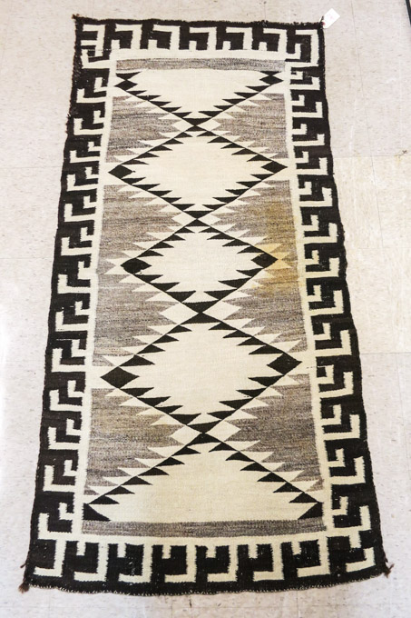 Appraisal: NAVAJO AREA RUG hand woven featuring a column serrated diamonds