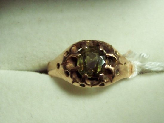 Appraisal: A green stone ring in a gold claw setting