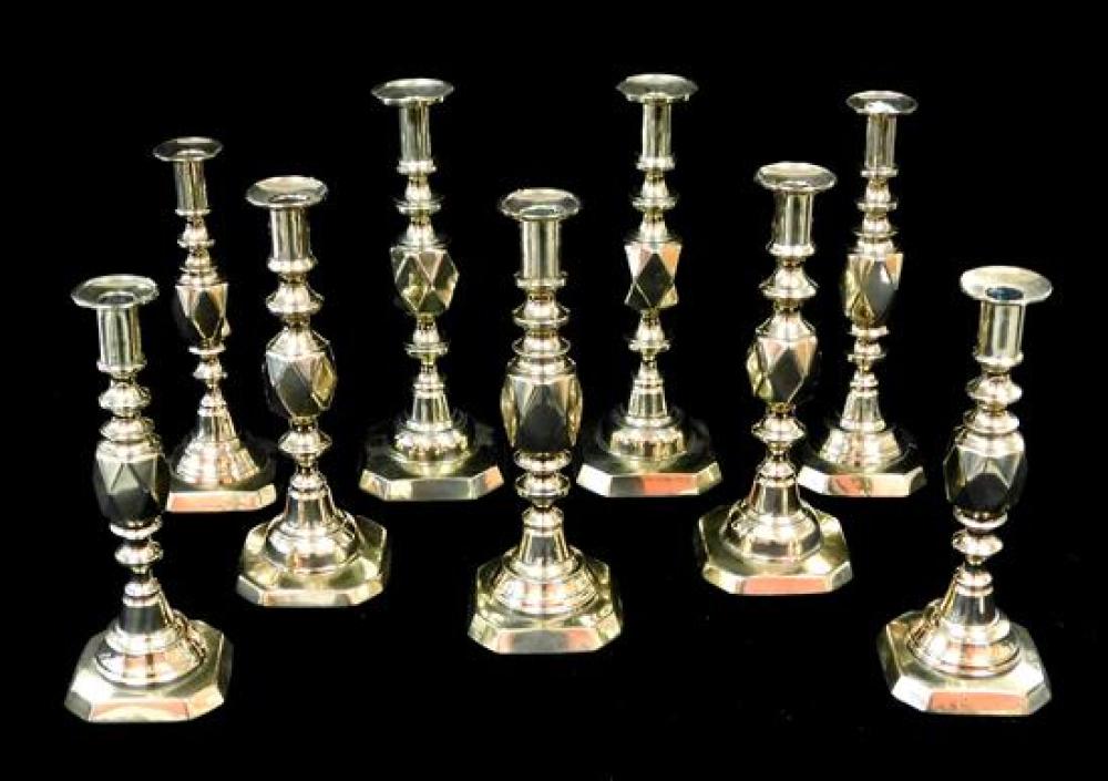 Appraisal: Nine brass Diamond pattern push-up candlesticks English details include Series