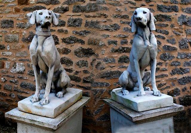 Appraisal: A pair of composite stone dogs sitting to attention each