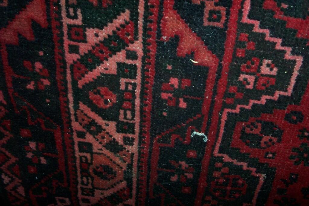 Appraisal: A red ground Eastern wool carpet with black and pink