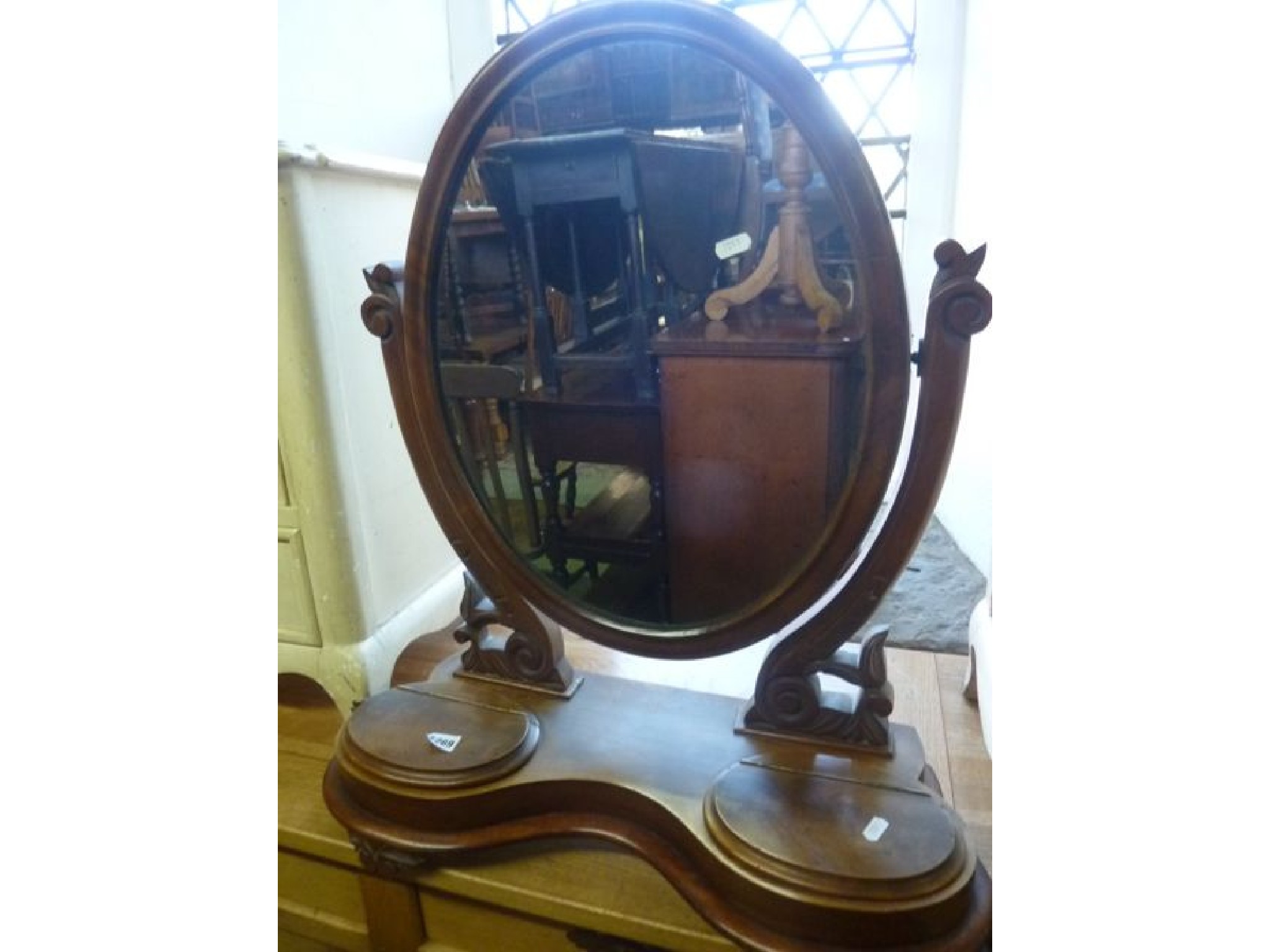 Appraisal: A Victorian mahogany toilet mirror of oval form raised on