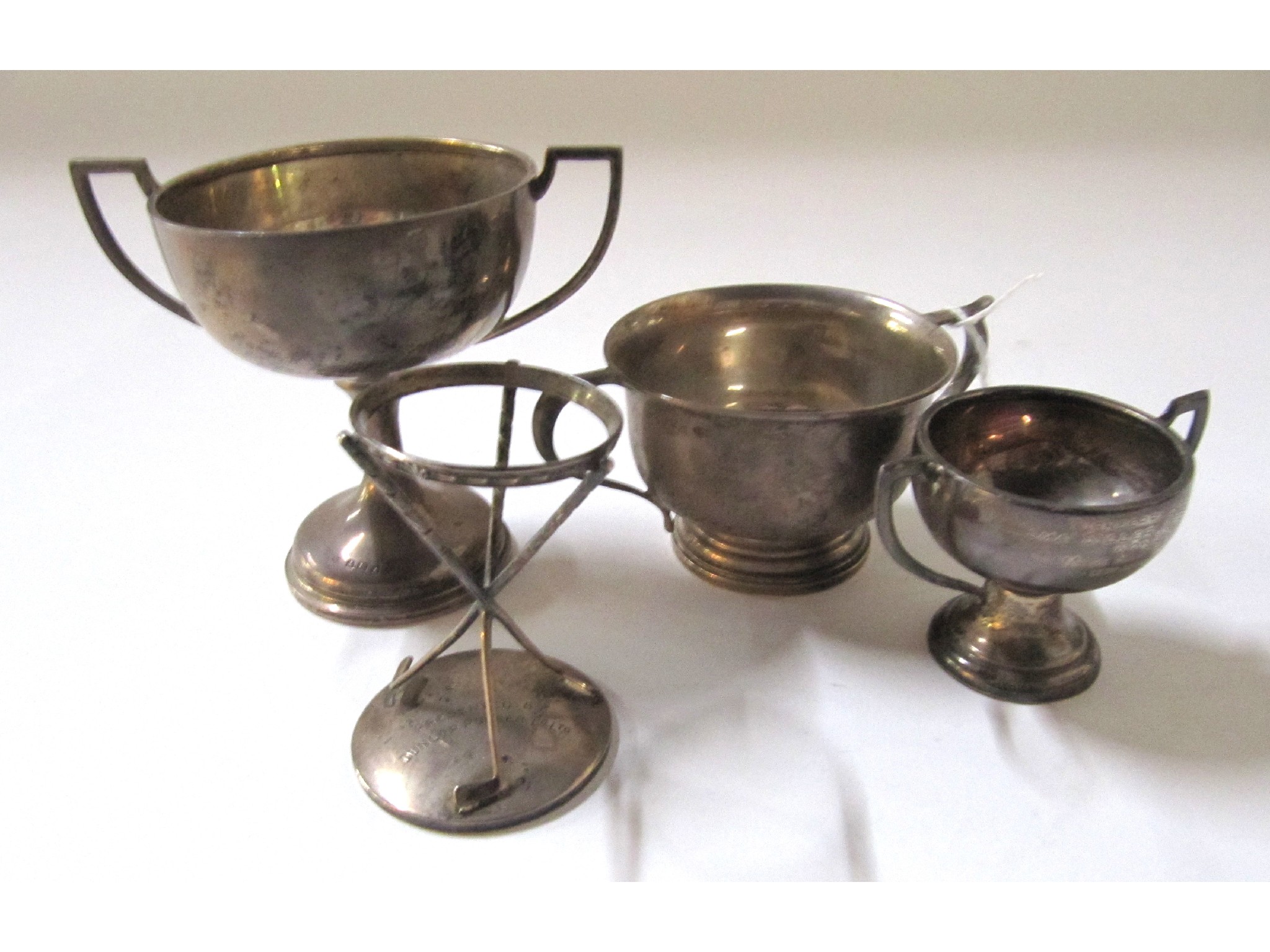 Appraisal: A lot comprising three silver trophy cups and a stand