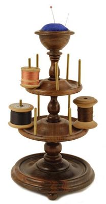 Appraisal: A turned rosewood bobbin stand with pincushion top and rotating