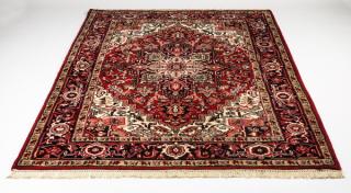 Appraisal: Hand knotted Indo-Heriz wool rug having a red geometric medallion