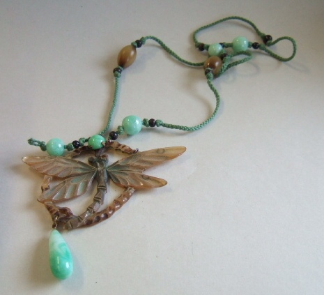 Appraisal: A stained horn pendant designed as a dragonfly within an