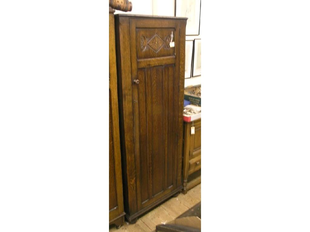 Appraisal: A dark oak hall wardrobe enclosed by single full-length panelled