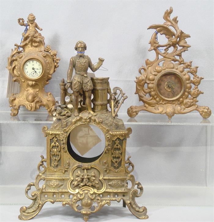 Appraisal: cast metal figural clock cases with rough movements tallest Estimate