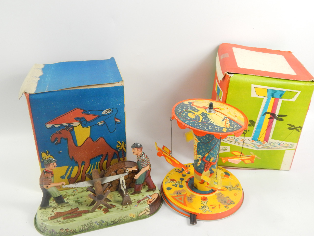 Appraisal: Two tin plate toy carousel rides each in a colourful