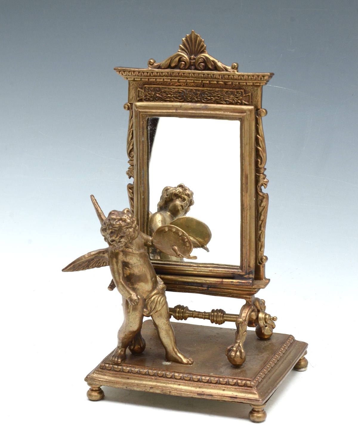 Appraisal: BRONZE CUPID WITH MIRROR Bronze framed mirror having a scrolling