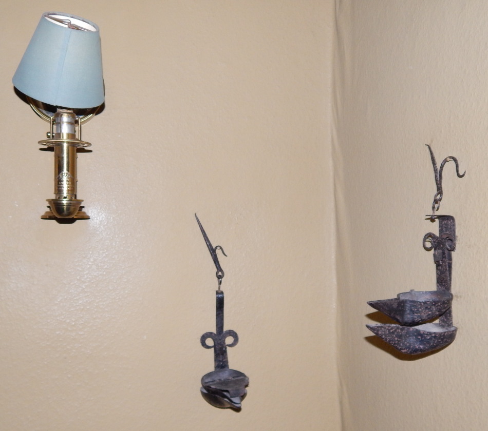 Appraisal: Two wrought iron wall mounted oil lamps and a brass