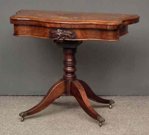 Appraisal: A Victorian walnut card table the green baize lined serpentine