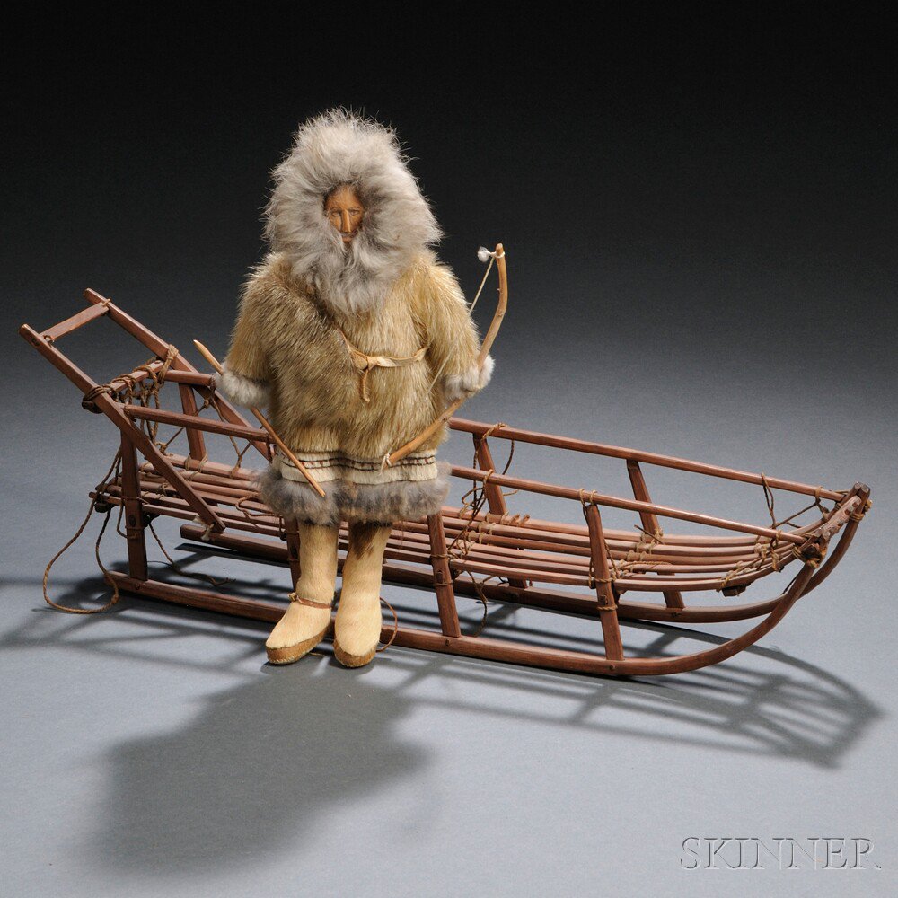 Appraisal: Two Eskimo Items a doll with wood face in a