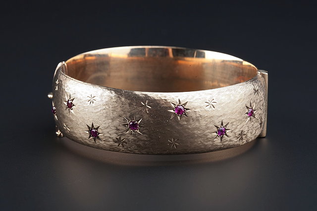 Appraisal: A CT GOLD AND RUBY SET BANGLE of wide hinged