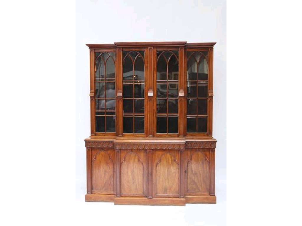 Appraisal: A GOTHIC REVIVAL MAHOGANY BREAKFRONT LIBRARY BOOKCASE in the manner