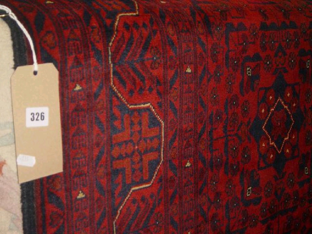 Appraisal: A red ground Eastern wool rug with repeating geometric decoration