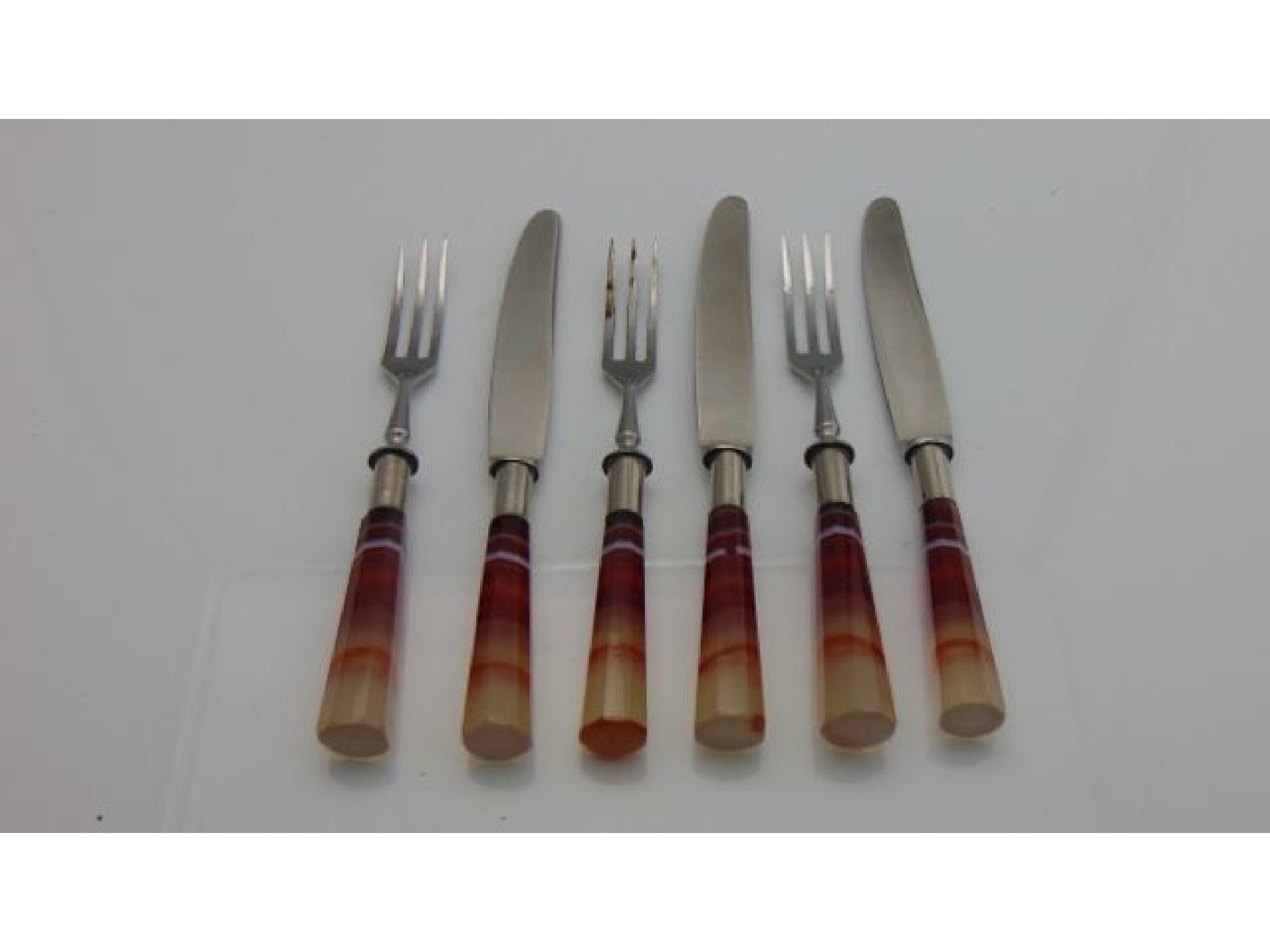 Appraisal: Three pairs of dessert knives and forks with polished steel