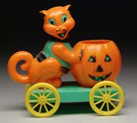 Appraisal: CAT PUSHING PUMPKIN ON WHEELS Orange cat on a green