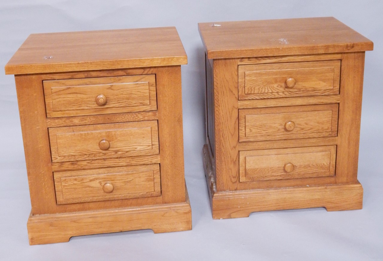 Appraisal: A pair of light oak three drawer bedside chests width