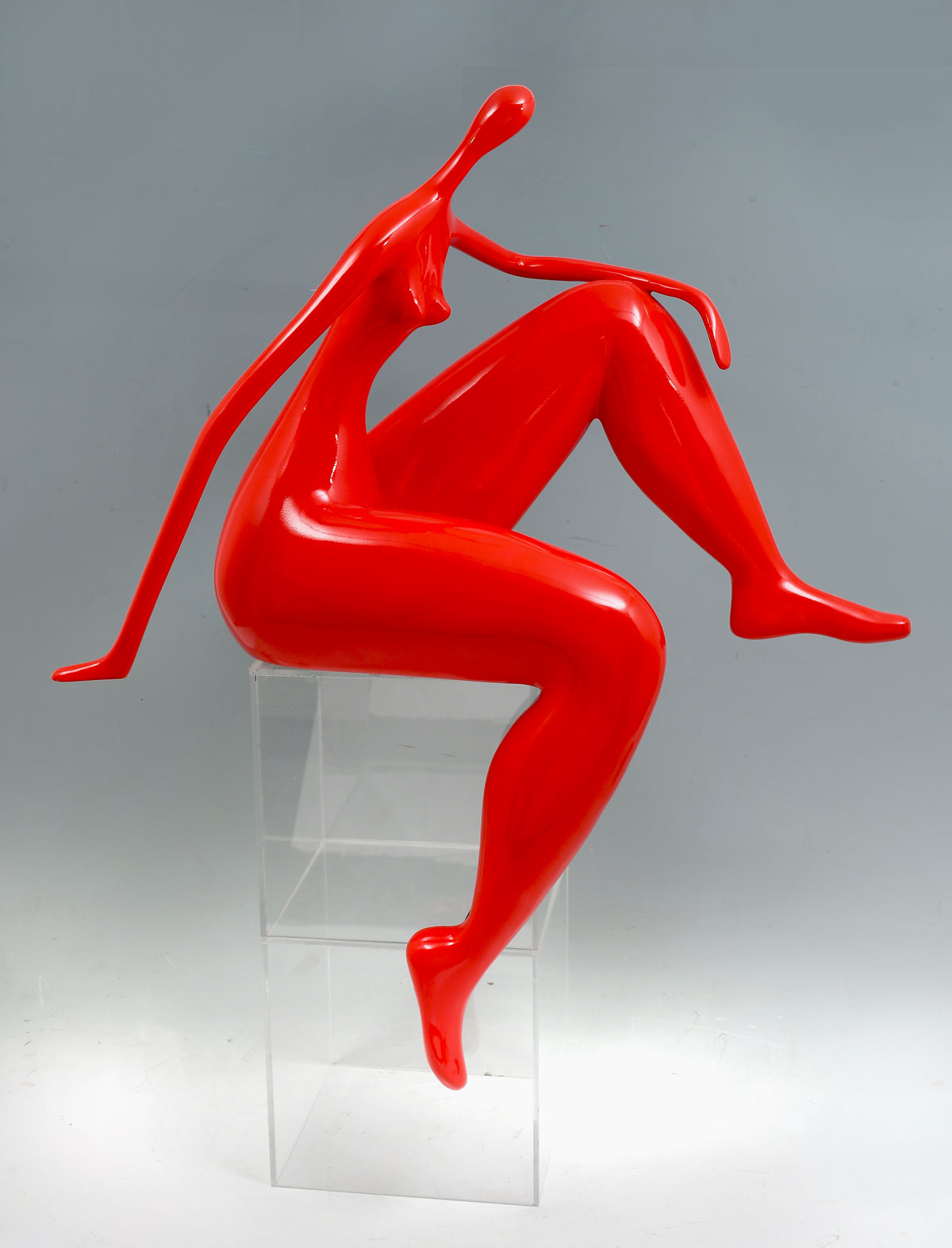 Appraisal: RED SEATED WOMAN RESIN SCULPTURE Stylized female form in red