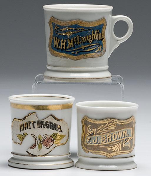 Appraisal: THREE NAMED MUGS WITH GLASS SHIELDS porcelain with enameled glass