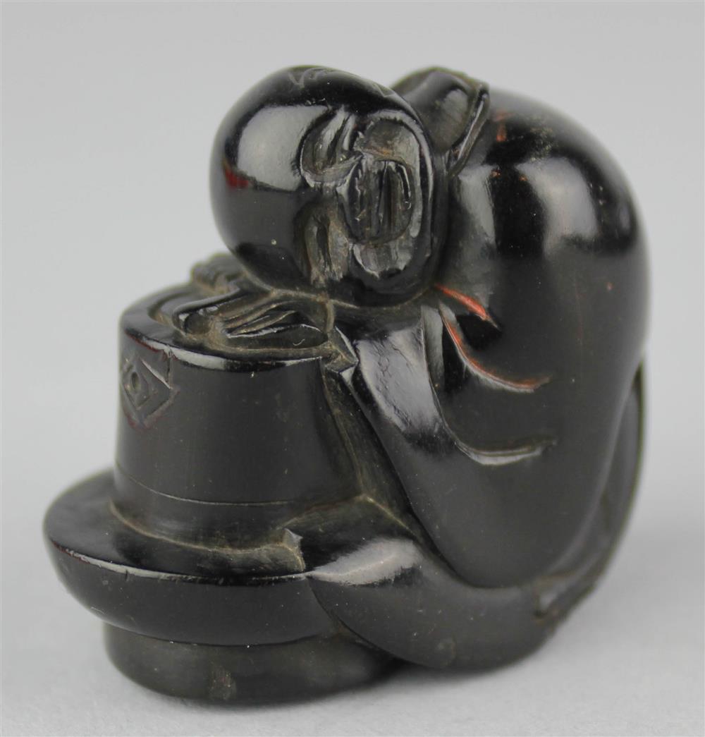 Appraisal: BLACK LACQUER NETSUKE OF A MAN ASLEEP ON HIS DRUM