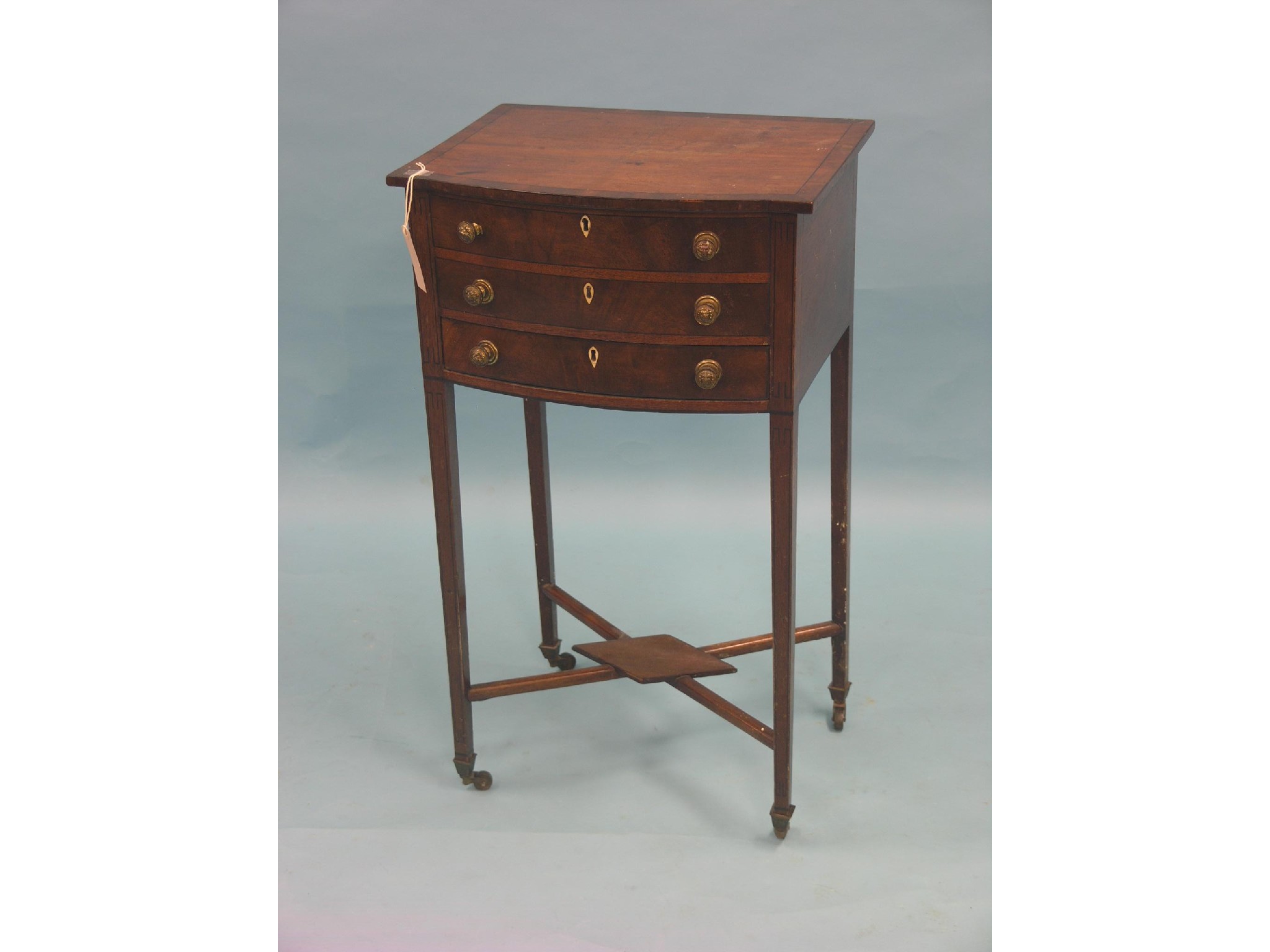 Appraisal: A Victorian bow-fronted mahogany needlework table hinged top above single