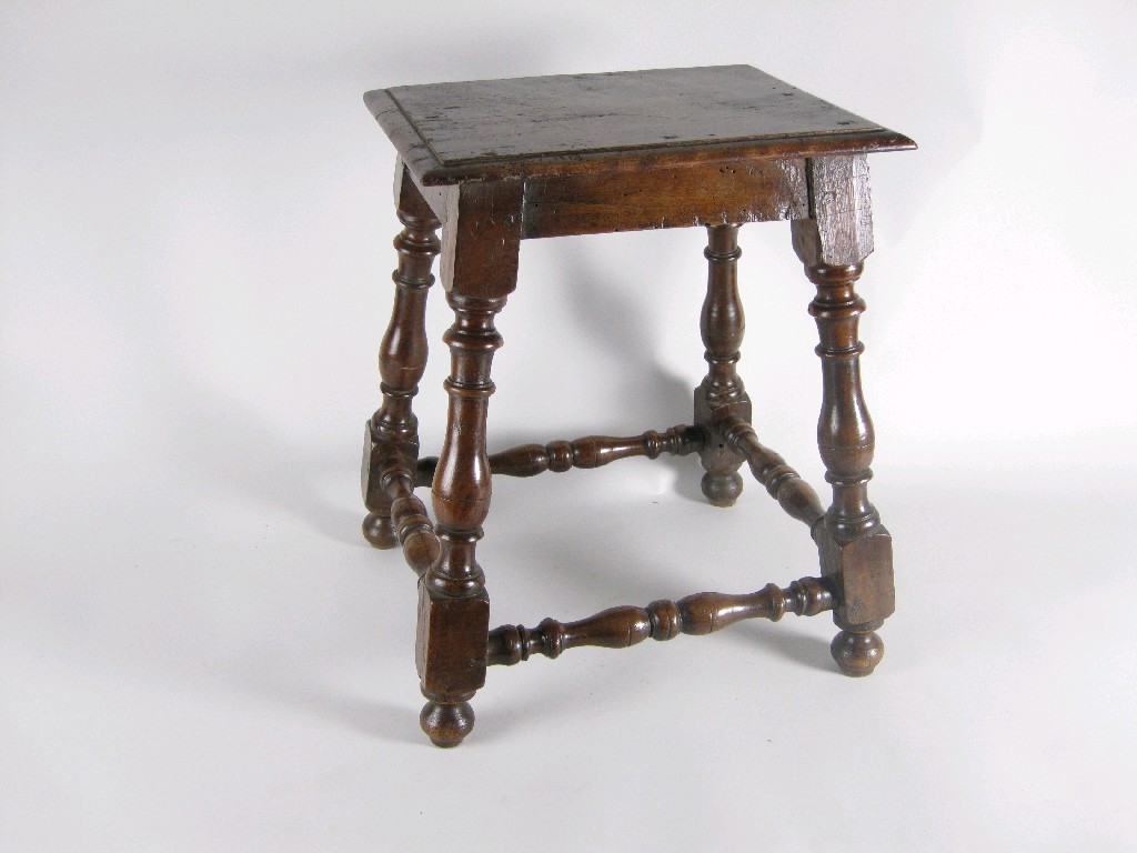 Appraisal: An Italian walnut Stool with turned baluster supports and stretchers