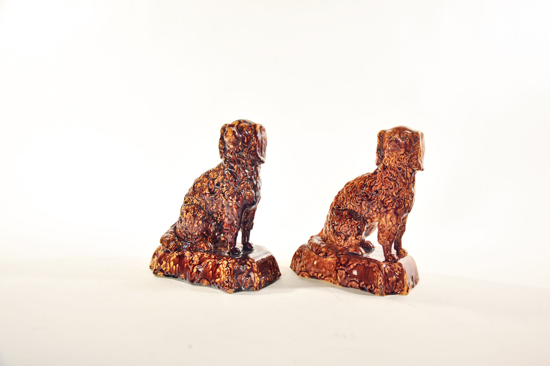 Appraisal: TWO ROCKINGHAM SEATED SPANIELS England mid th century Mottled brown