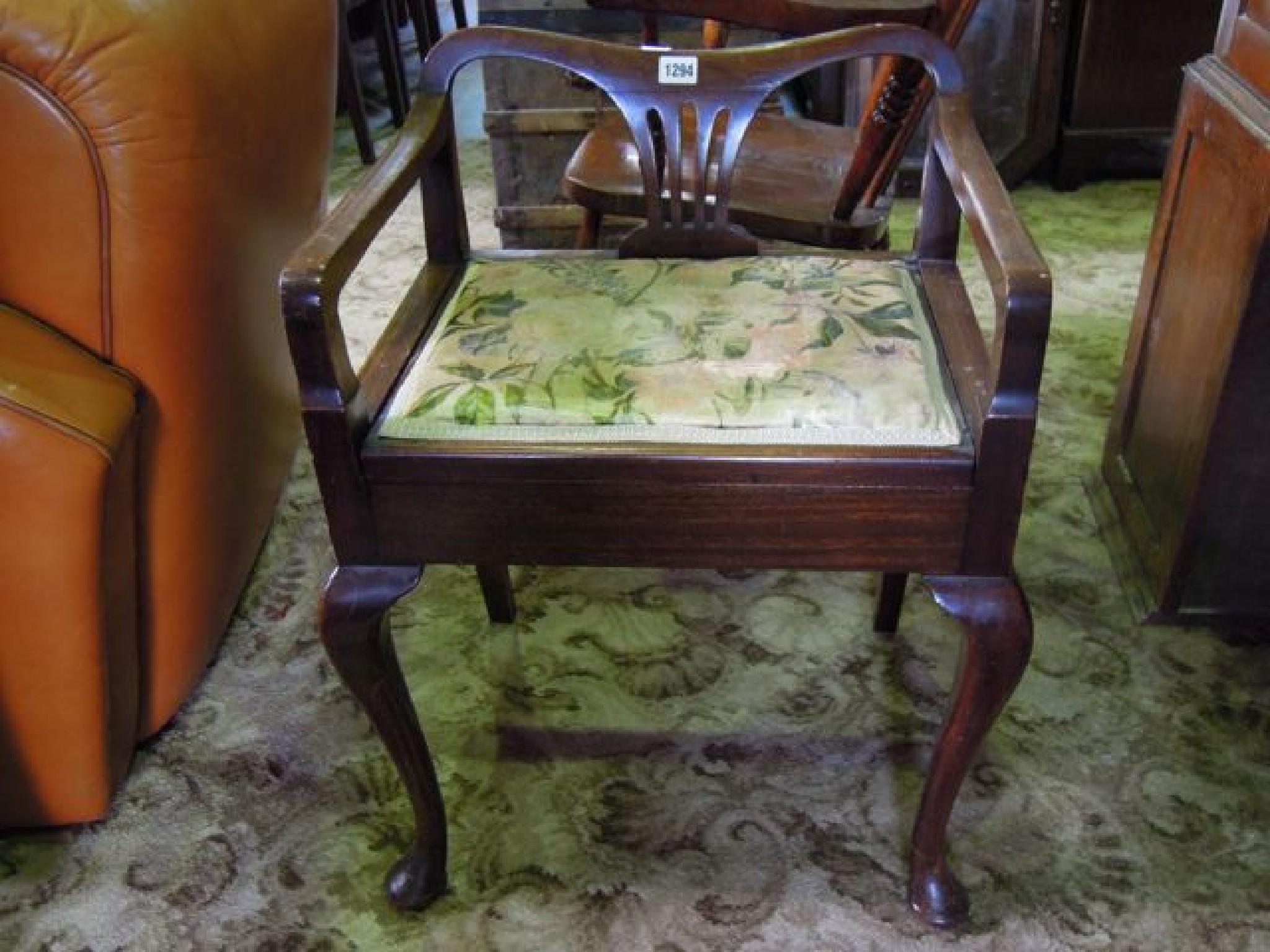 Appraisal: An Edwardian mahogany piano stool with box seat shaped arms