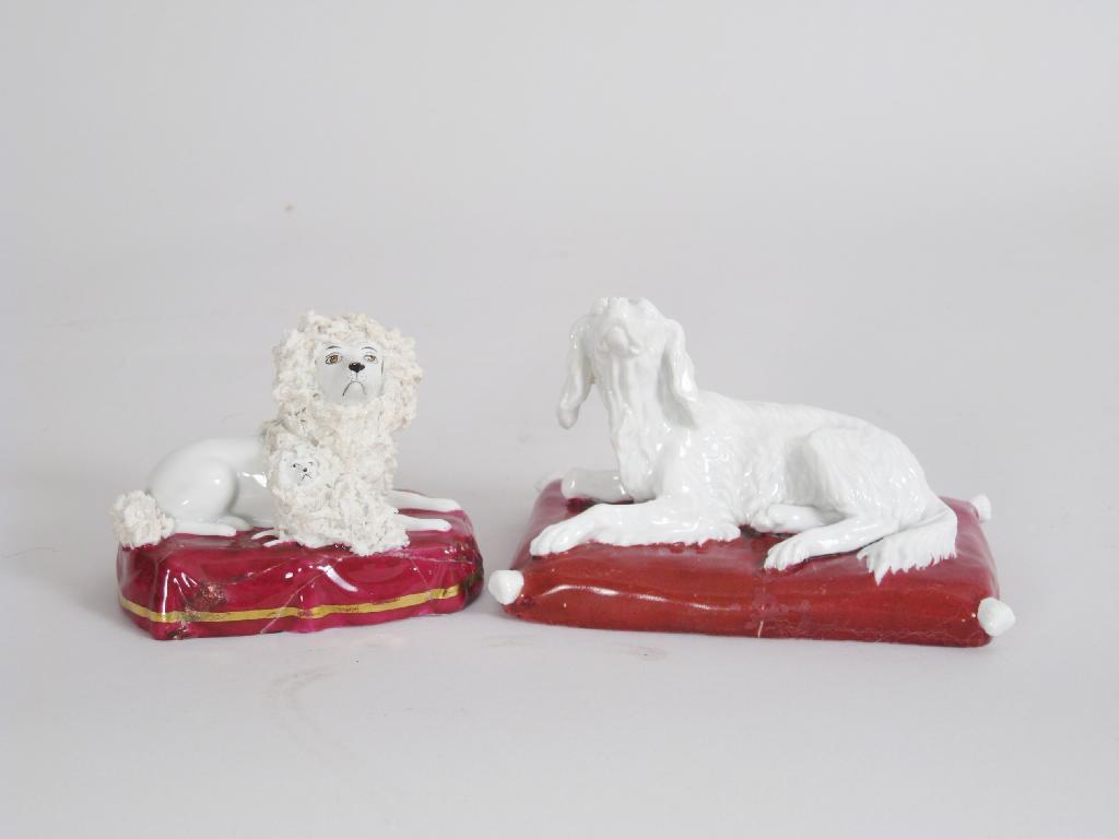 Appraisal: Two Continental porcelain Figures of recumbent dogs with red painted