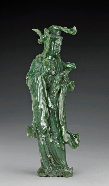 Appraisal: A 'spinach' jade figure of Guanyin th Century Holding a