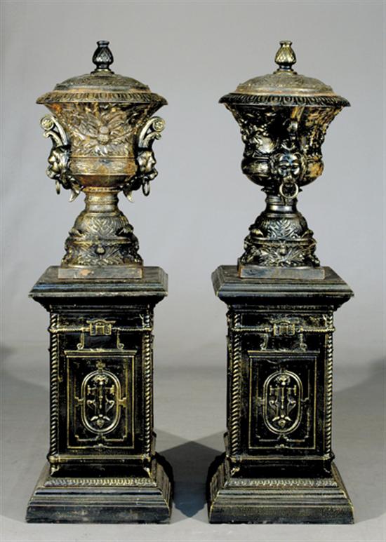 Appraisal: Pair covered cast-iron garden urns on stands lid with pineapple