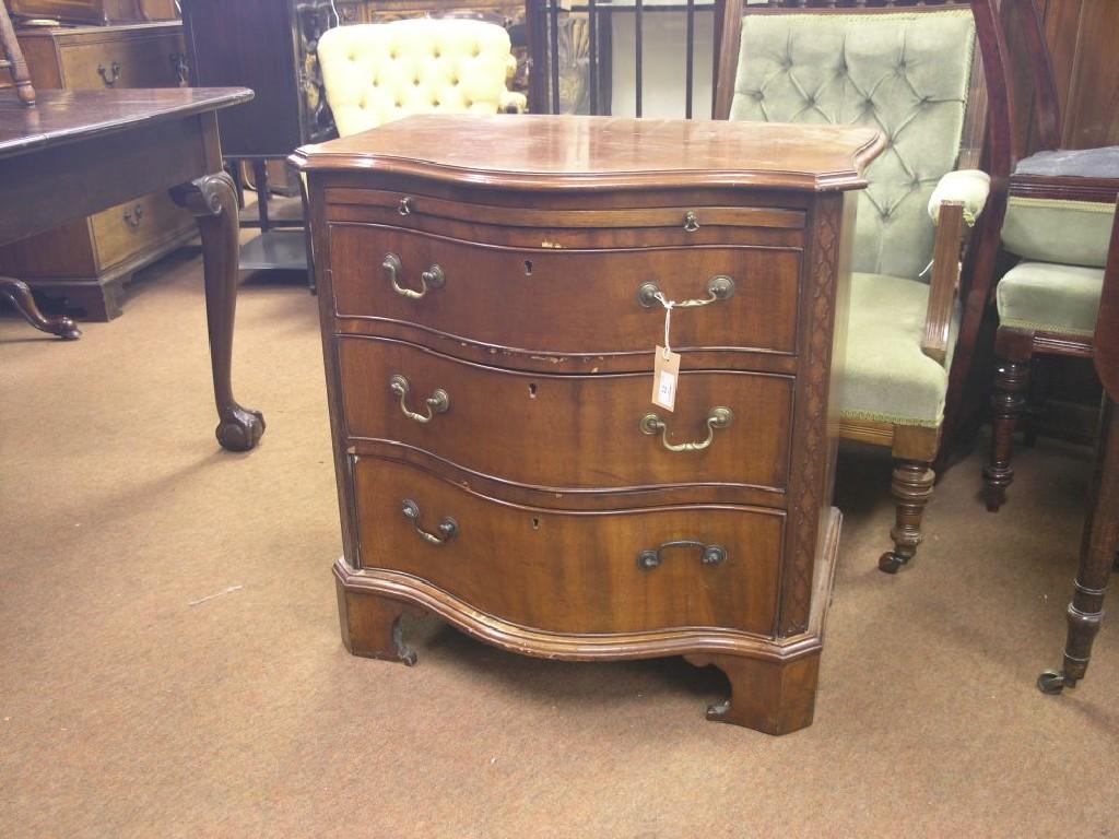 Appraisal: A Chippendale-style mahogany serpentine-fronted chest bold serpentine-shape with brushing slide